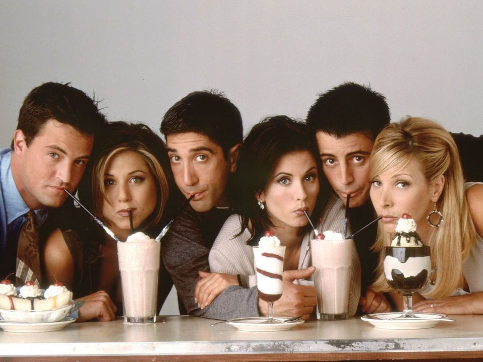 Picture of three men and three women sipping out of milkshakes